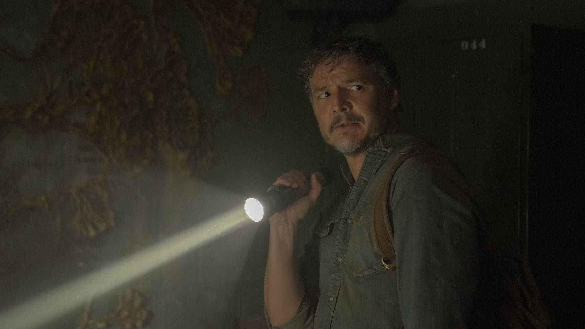 Joel segurando uma lanterna ligada na mão direita